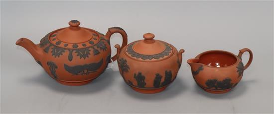 Three Wedgwood Rosso Antico items - a teapot and cover, milk jug and sucrier